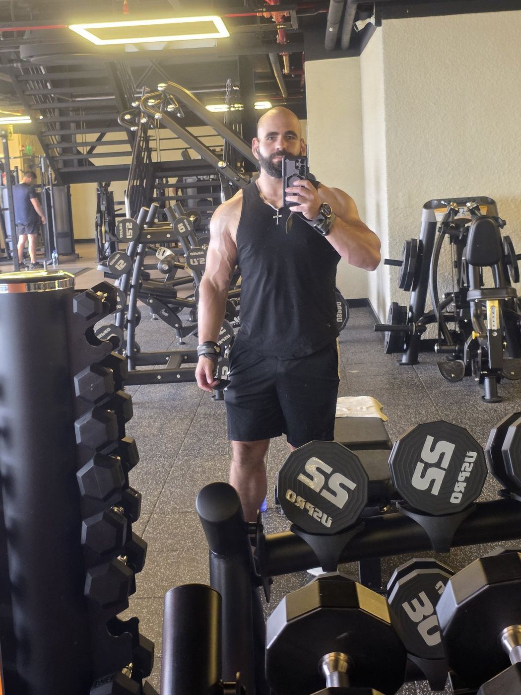 Renzo de cuerpo entero en el gimnasio junto al rack de mancuernas después de bajar 60 kilos